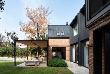 Hicieron la pérgola (Radovic Arquitecto por Herrería Oak) con estructura de hierro negro, techo de vidrio y varillado de incienso. El piso exterior (Holstein) es de Travertino al agua con acabado rústico.