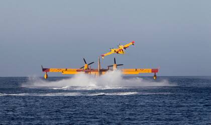 Hidroaviones de los bomberos cargan agua para apagar las llamas