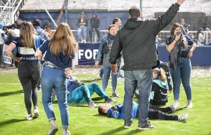 Hinchas en el suelo afectados por los gases lacrimógenos