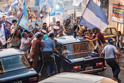 Hinchas y reporteros rodean el auto en el que va Diego Maradona en pleno furor por el Mundial México 86