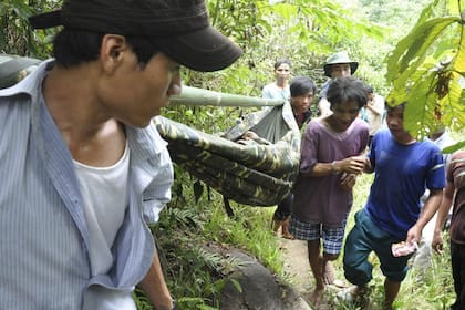 Ho Van Lang y su padre, Ho Van Thanh, en camilla, al ser encontrados