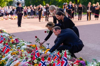 La reina Mette-Marit, la reina Sonia, la princesa Marta Luisa y el rey Haakon VIII, en la plaza del palacio, contemplando el mar de flores y mensajes dejados por los ciudadanos