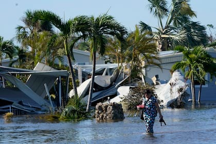 Holly Nugyn recorre su vencindario inudnado el 29 de septiembre de 2022 tras el paso del huracán Ian en Fort Myers, Florida. (AP Foto/Steve Helber)