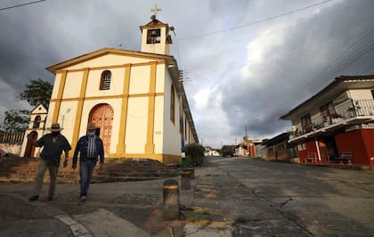 Hombres con máscaras para frenar la propagación del coronavirus caminan en municipio