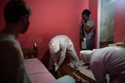 Hombres vestidos de pies a cabeza con trajes de protección llevaron un ataúd vacío hasta la pequeña vivienda blanca y azul donde Edgar Silva había pasado dos febriles días intentando respirar