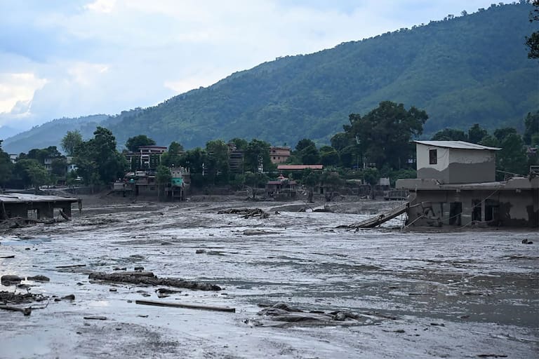 Houses lie deluged in sludge following flash floods at Devghat in Nepal's Nuwakot district on August 26, 2026. Massive flooding killed eight people in Nepal on August 26, as Chinese state media reported "major casualties" from a mudslide at a Tibet trade hub on China's side of the nations' shared border. (Photo by Prakash MATHEMA / AFP)
