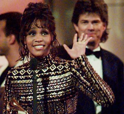 Houston tras ganar el Grammy por I Will Always Love You, junto al productor David Foster