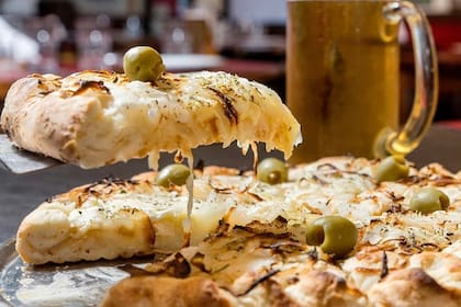 Hoy se celebra la noche de la pizza y la empanada, con descuentos de hasta un 50%