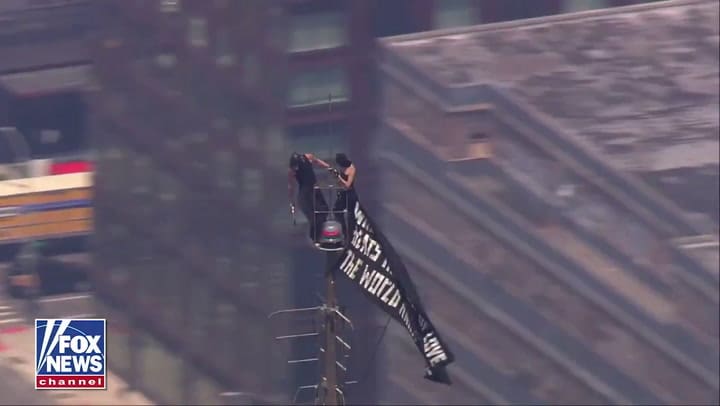 Dos personas trepan el Empire State