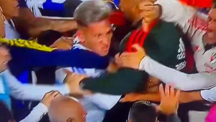 Diego Moreno, encargado de seguridad de River, intentando contener a un desbocado Luis Vázquez