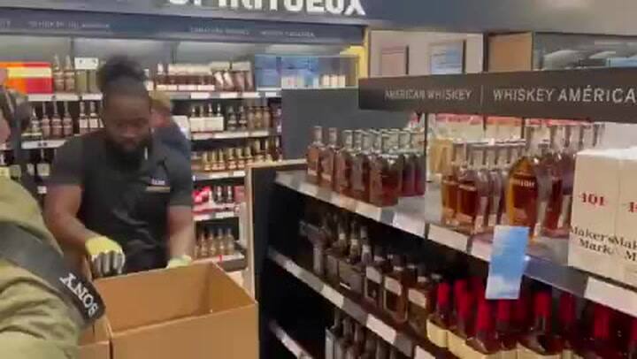 Un hombre retira botellas de alcohol estadounidense en Canadá