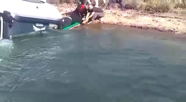 El momento en el que vecinos sacan del agua al chofer