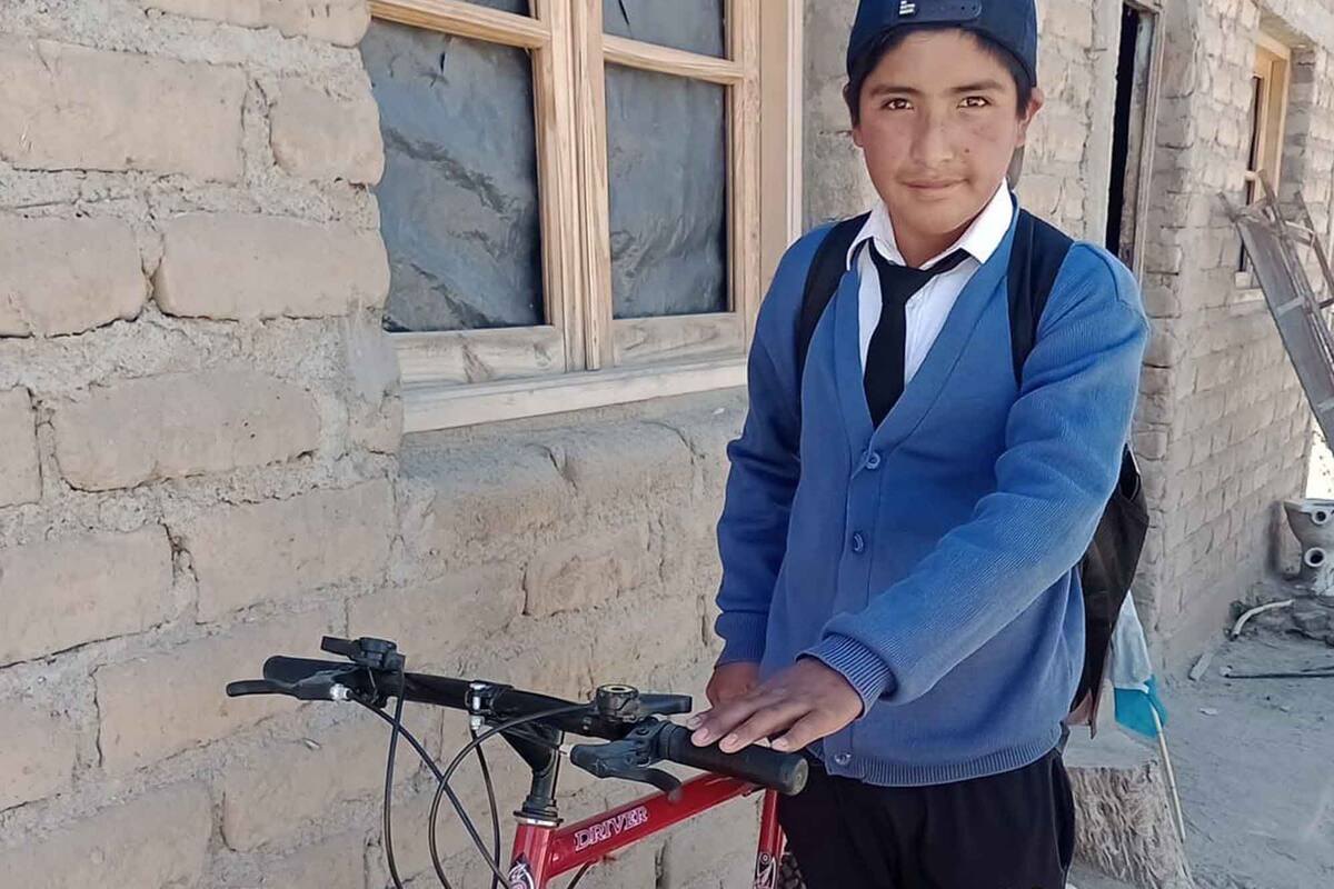 Humberto feliz con su bici nueva con la que ahora va al colegio