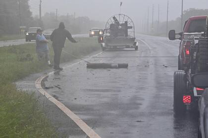 Un grupo de personas retira escombros de una autopista en Cross City, Florida, el 30 de agosto de 2023, después de que el huracán Idalia tocara tierra