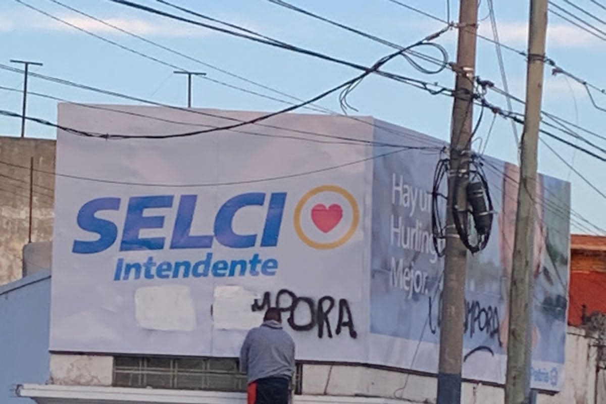 Hurlingham. Militantes borran una pintada de La Cámpora en el cartel del candidato a intendente que, curiosamente, es de La Cámpora