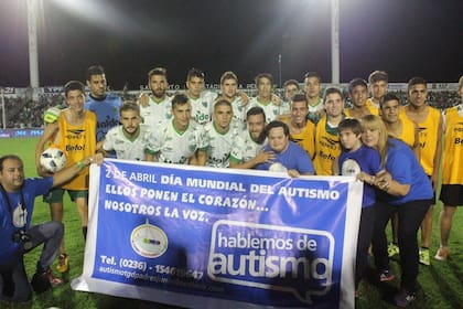 Ian y Alvaro con el plantel de Sarmiento, en una campaña de concientización sobre el autismo