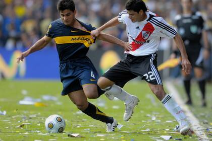 Ibarra lleva la pelota y trata de impedírselo un juvenil Wálter Bou; fue en la Bombonera, en 2009, cuando Boca y River empataron 1 a 1 (el gol millonario lo hizo Gallardo)