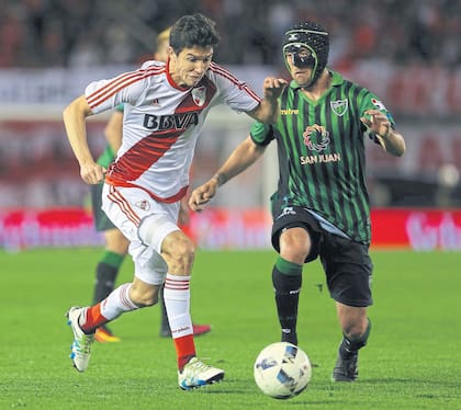 Ignacio Fernández se lleva la pelota ante la marca del enmascarado Fissore; el zurdo asistió a Alario en el 1-