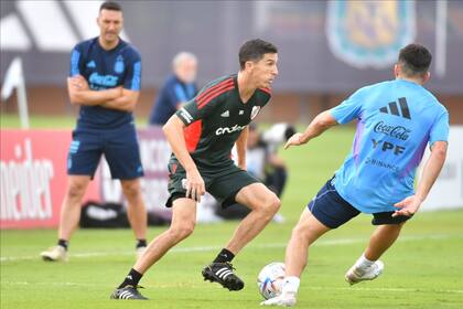 Ignacio 'Nacho' Fernández maneja la pelota ante la mirada de Lionel Scaloni en un amistoso