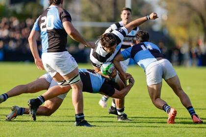 Ignacio Torrado recibe un embate de Segundo Pisani y otro de Francisco Pastrono; CUBA, que había perdido sus seis partidos, fue un freno para el andar lujoso que ostentaba CASI en el Top 12 de URBA.