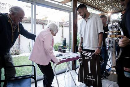 Ignacio Vázquez, capitán de Platense, le acercó a la abuela la camiseta personalizada de campeón