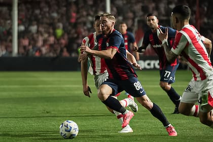Iker Muniain, de lo poco rescatable en San Lorenzo, conduce la pelota entre Nicolás Dubersarsky y Giuliano Cerato, de Instituto; el Ciclón se hunde en la Liga Profesional.