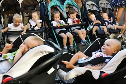 Imagen de archivo del 11 de agosto de 2018 donde gemelos y trillizos se sientan en su cochecito cuando llegan al Festival de los gemelos para niños, en Kiev. (Foto: Sergil Supinsky - AFP)