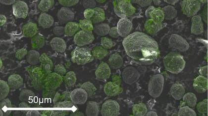 Imagen de microscopio electrónico de barrido de las microperlas de grafito recubiertas. Las regiones verdes indican silicio y confirman la presencia del revestimiento aislante