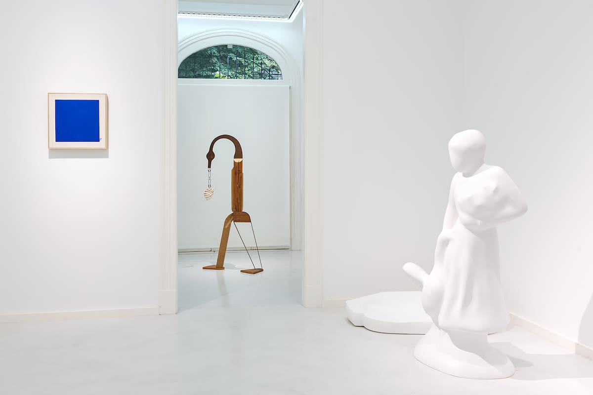 Imagen de sala de la muestra "Neurocisne", en MCMC Galería: "Cisne negro detrás de cuadrado azul" (Azul Caverna), "Podés hacer copia" (Alita Olivari) y esculturas sin título de Elba Bairon