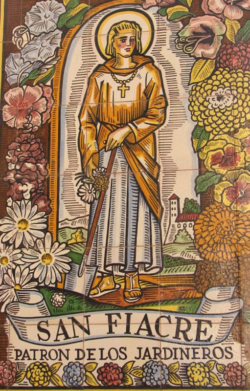 Imagen de San Fiacre pintada sobre azulejos en un jardín de Sevilla, España.