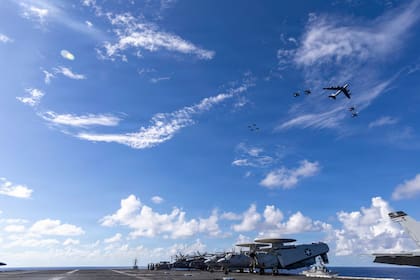Imagen difundida por el Departamento de Defensa de Estados Unidos que muestra a los destructores USS Mahan y USS Bainbridge navegando en formación mientras un F/A-18 Super Hornet aterriza en el portaaviones USS Gerald R. Ford en el Atlántico, el 13 de noviembre de 2025