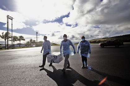 Imagen difundida por la Municipalidad de Rapa Nui que muestra a los trabajadores de la salud descargando una caja con casi 1200 dosis de la vacuna CoronaVac desarrollada por Sinovac, a su llegada al Aeropuerto Internacional de Isla de Pascua, en Rapa Nui, Chile, el 4 de febrero de 2021