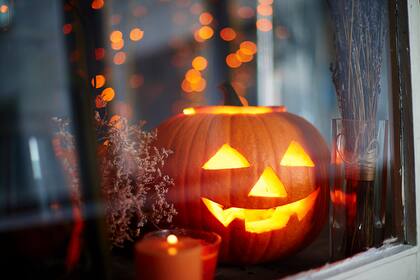 Imagen genérica de una calabaza de Halloween mirando por la ventana.
