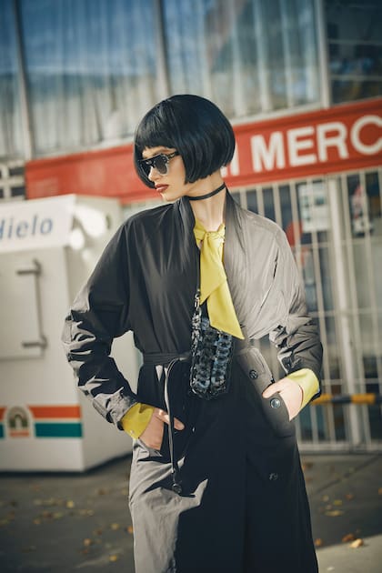Impermeable con lazo (Mishka), camisa de satin con lazo y portacelular de cuero trenzado (Prüne). Anteojos de sol redondos (Vulk)