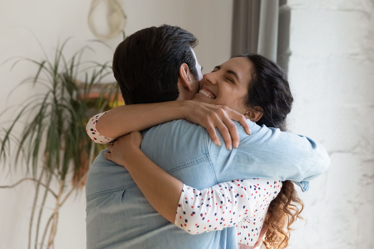 In your warm embraces. Excited wife holding beloved husband tight in arms grateful for support love care. Young couple hug reconciling after family fight or missing each other spending long time apart