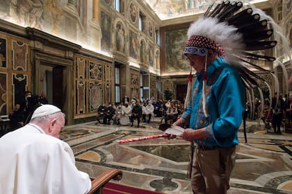 El Papa recibió un regalo del jefe de una delegación durante una audiencia con las miembros de la comunidad indígena de Canadá en el Vaticano