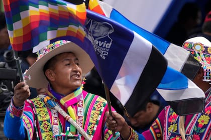 Indígenas quechua partidarios del presidente boliviano, Luis Arce, ondean banderas Wiphala en un acto de celebración por los 29 años de la fundación del partido oficialista, el Movimiento al Socialismo (MAS), en La Paz, Bolivia, el jueves 28 de marzo de 2024. (AP Foto/Juan Karita)