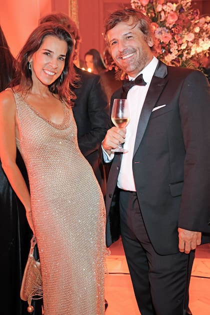 Inés Etchebarne, con un vestido dorado, y Pedro Lines.