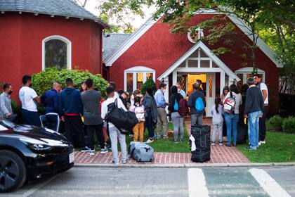Inmigrantes se congregan frente a la iglesia episcopal de San Andrés, el 14 de septiembre del 2022, en Martha's Vineyard, Massachusetts. (Ray Ewing/Vineyard Gazette vía AP)