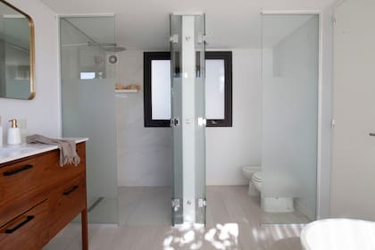 Inodoro y bidet (Ferrum). Las paredes de la sala de ducha y la del lateral de la bañadera están revestidas con Dekton ‘Natura’ (Canteras del Mundo).