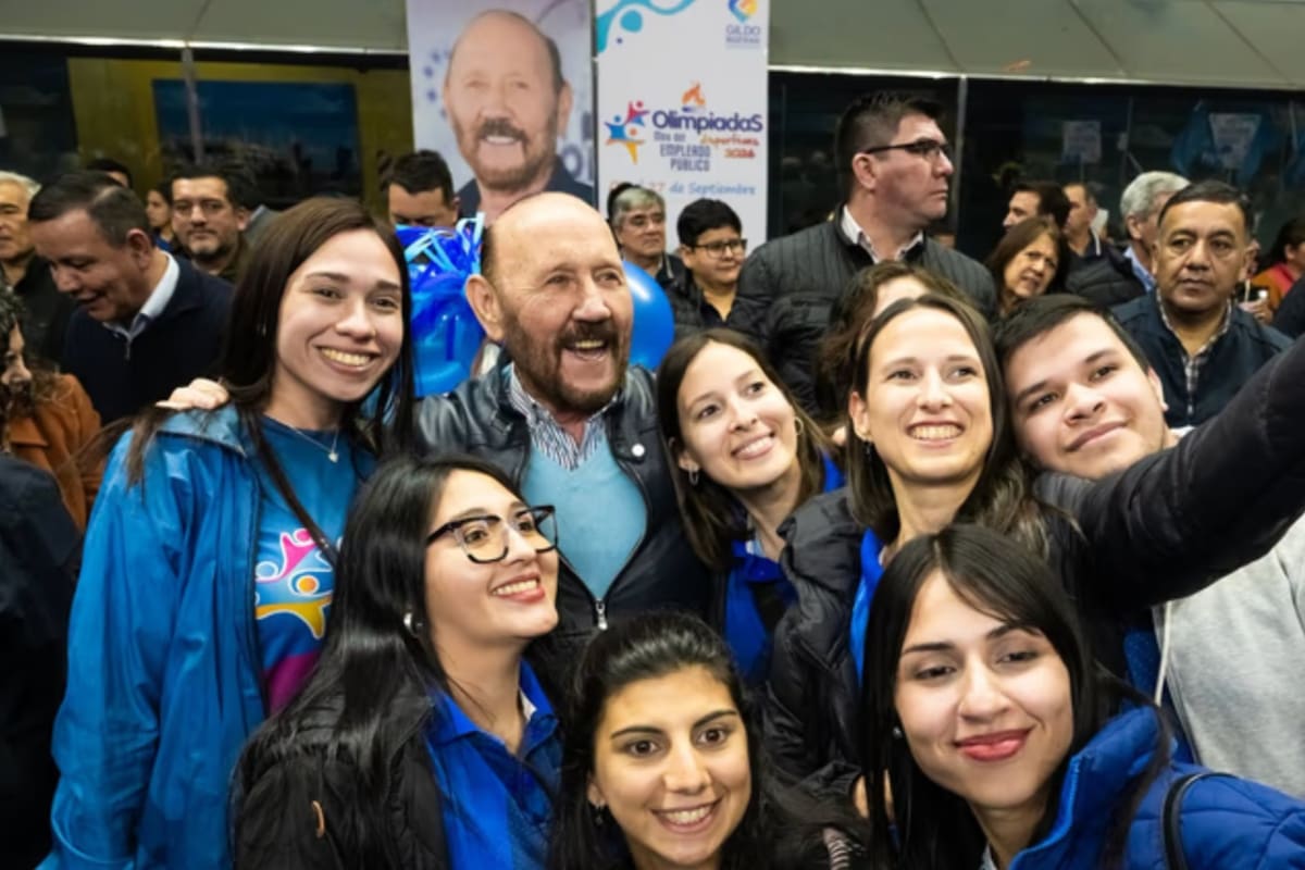 Insfrán posa con jóvenes que participan de los juegos, con su imagen de fondo. Para la oposición, el inminente final de su largo mandato, acentuó su personalismo.