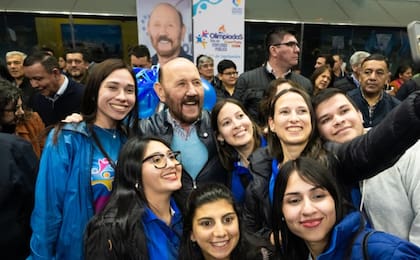 Insfrán posa con jóvenes que participan de los juegos, con su imagen de fondo. Para la oposición, el inminente final de su largo mandato, acentuó su personalismo.