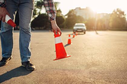 Instructor sets the cone, driving school concept