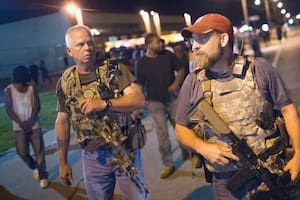 Integrantes de los Oath Keepers portan rifles en Ferguson, Misuri, en el primer aniversario del tiroteo de Michael Brown en 2015