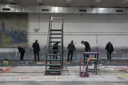 Integrantes del Taller de Escenografía trabajan sobre una gran superficie pintada utilizando la técnica conocida como “pintura a la italiana”, una tradición escenográfica centenaria que aún se conserva en el Teatro Colón.