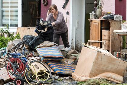 Una mujer junto a los destrozos provocados por la inundación