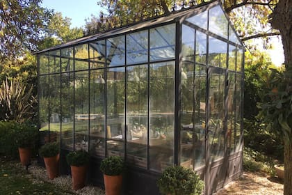 Invernadero realizado con estructura de hierro, techo de vidrio de seguridad, con los paños laterales fijos de vidrio, y algunas ventanas o banderolas para abrir. El zócalo puede ser de chapa o de vidrio armado (La forge).