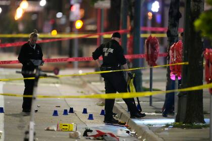 Investigadores del Departamento de Policía de Denver, trabajan en la escena de un tiroteo masivo en Market Street, entre la 20ma y la 21ra avenidas, durante al celebración del título de la NBA de los Nuggets, el 13 de junio de 2023, en Denver. (AP Foto/David Zalubowski)