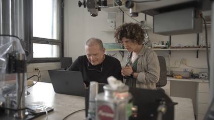 Investigadores del Laboratorio de Sistemas Dinámicos del Departamento de Física, en la Facultad de Ciencias Exactas y Naturales de la UBA, diseñaron un modelo físico para reproducir el canto del chingolo. El dispositivo “utiliza modelos matemáticos y de Inteligencia Artificial y permite tanto recuperar cantos antiguos de estas aves como generar “nuevas canciones” que son imitadas y aprendidas por los pichones de esta especie”, explica Gabriel Mindlin, director del Laboratorio (en la foto, junto a Ana Amador)