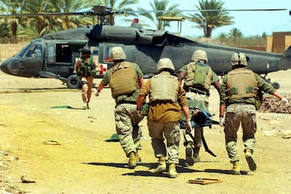 Irak: médicos de la Marina cargan con un infante herido durante un ataque en Ramadi, al oeste de Bagdad